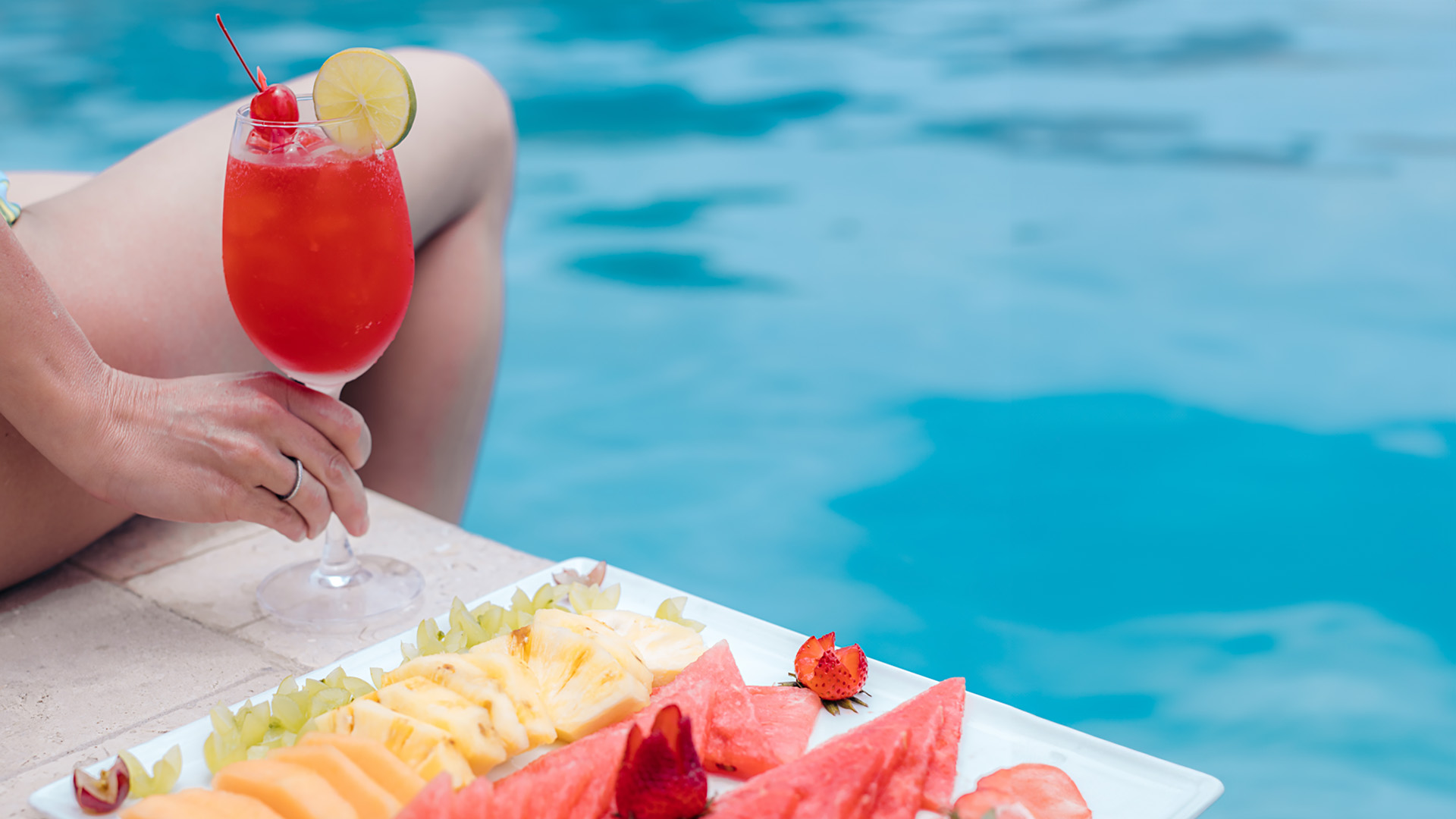 Poolside tropical cocktail and fresh fruit platter